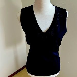 Black v-neck, sleeveless knit top.